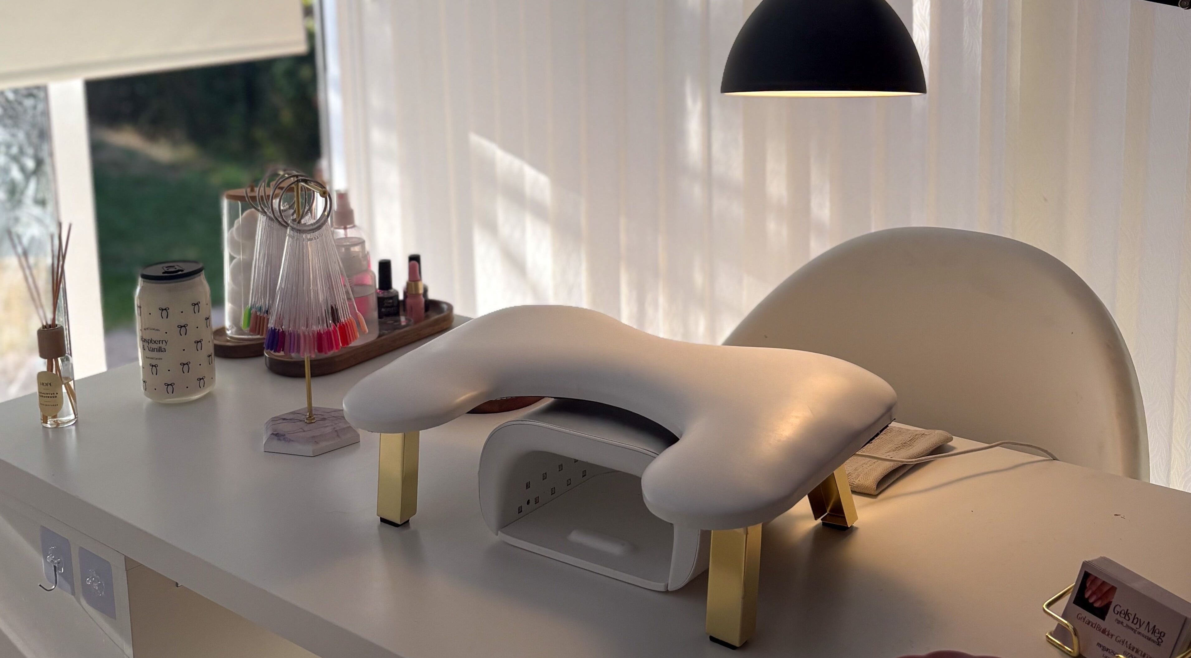 Manicure setup at Gels by Meg in Welshpool, Wales, GB showcasing polish displays and cozy atmosphere.