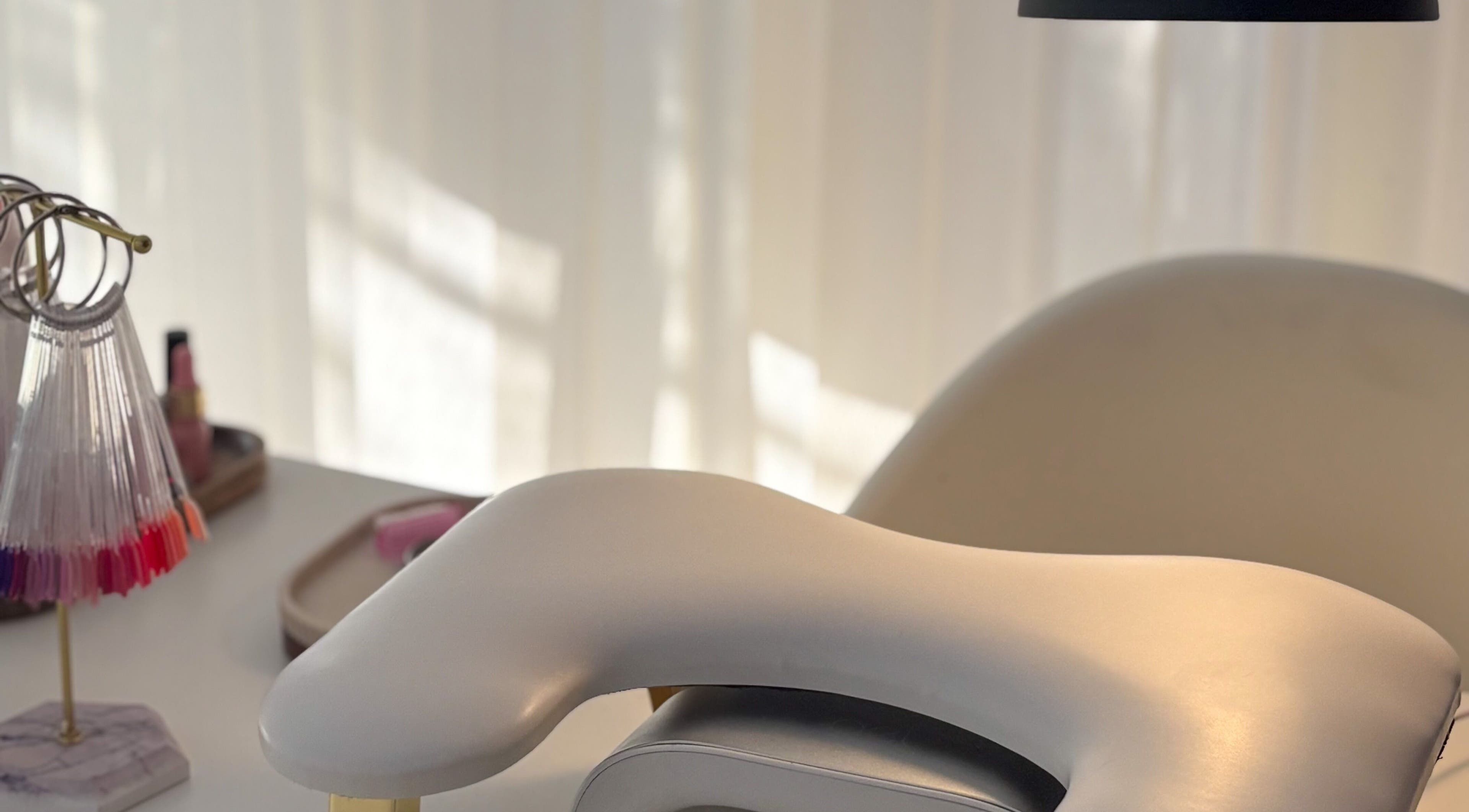 Elegant manicure station at Gels by Meg in Welshpool, Wales, GB with nail polish samples and comfy chair.