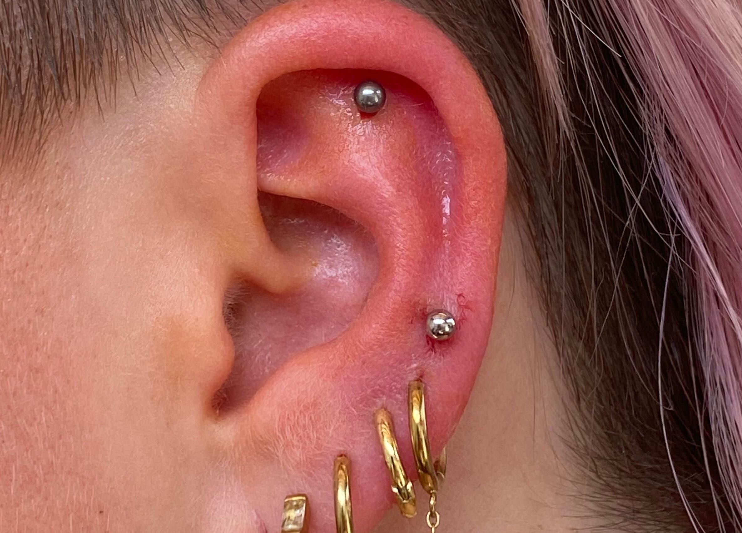 Piercing élégant à l'oreille chez Vices Underskin, Lille, Hauts-de-France, FR, bijoux dorés.