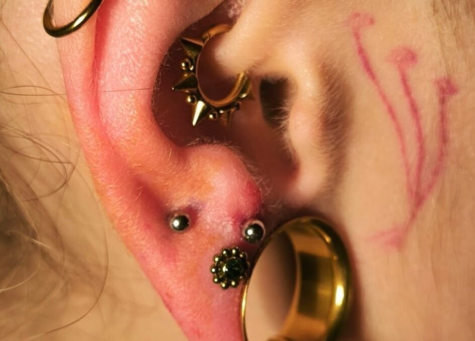 Piercing créatif à Vices Underskin, Lille, Hauts-de-France, FR, mettant en valeur boucles dorées et tatouages.