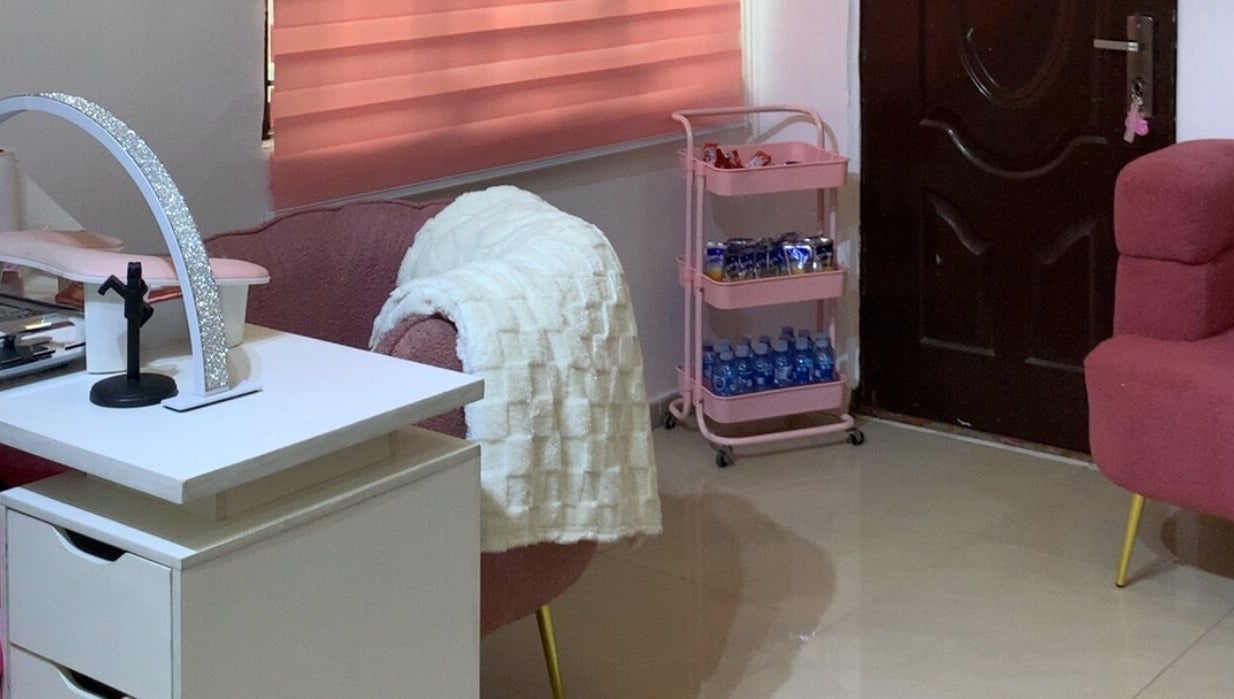 Cozy interior of Nailed by Mokz, Lekki, Lagos, NG featuring pink chairs and a manicure desk.