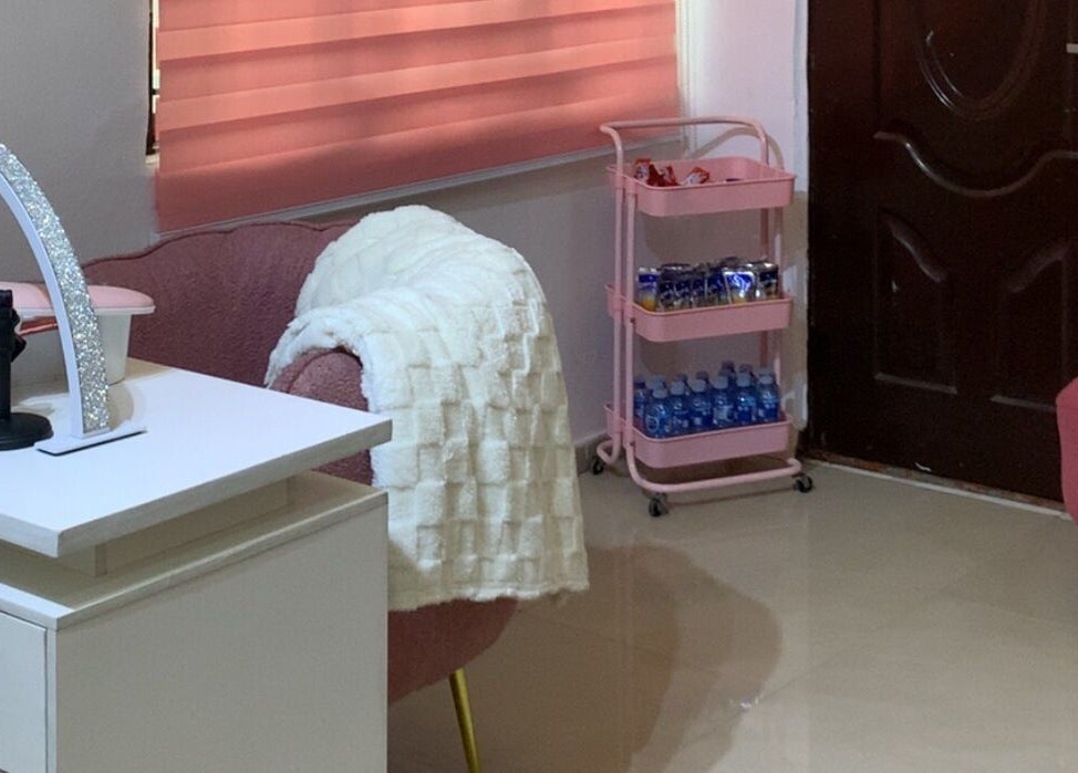 Cozy interior of Nailed by Mokz, Lekki, Lagos, NG featuring pink chairs and a manicure desk.