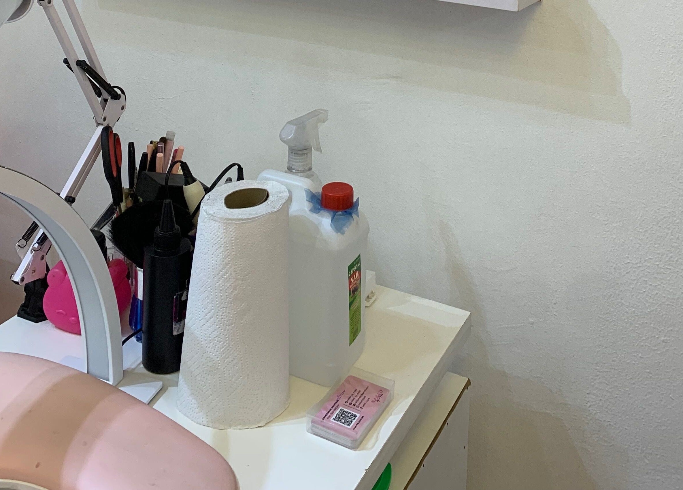 Nail care essentials at Nailed by Mokz, Lekki, Lagos, NG. Tools and products on a white desk.