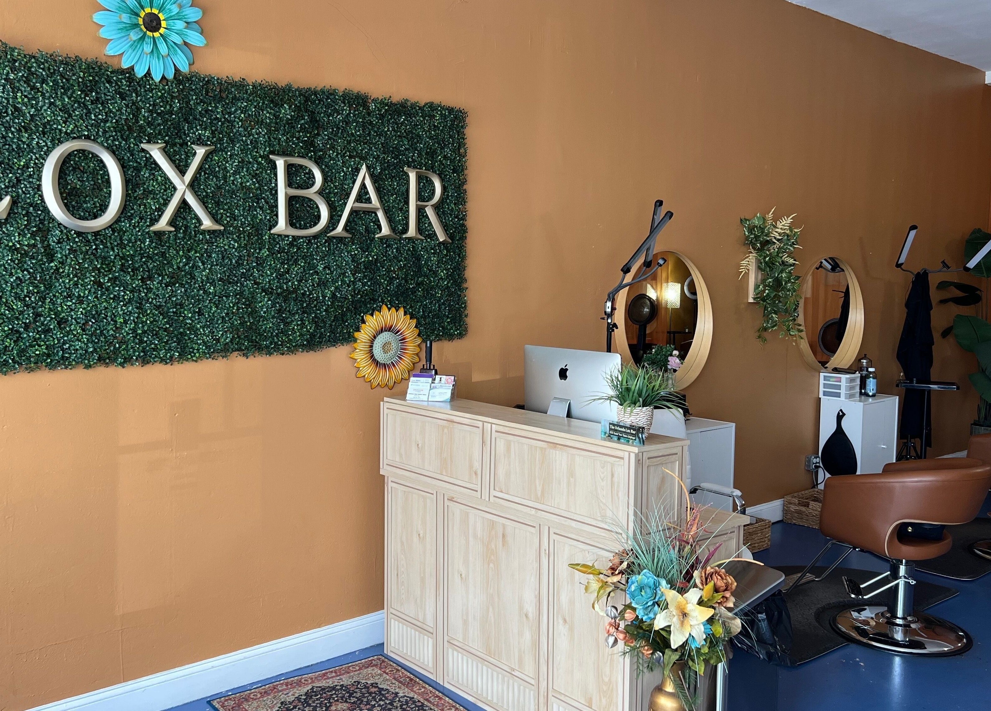 Inside Orlando Lox Bar in Orlando, Florida, US - stylish salon stations with vibrant decor and green wall accents.