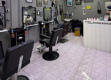 Interior of Street Crew Barbershop, Kuala Lumpur, featuring stylish chairs and modern decor.