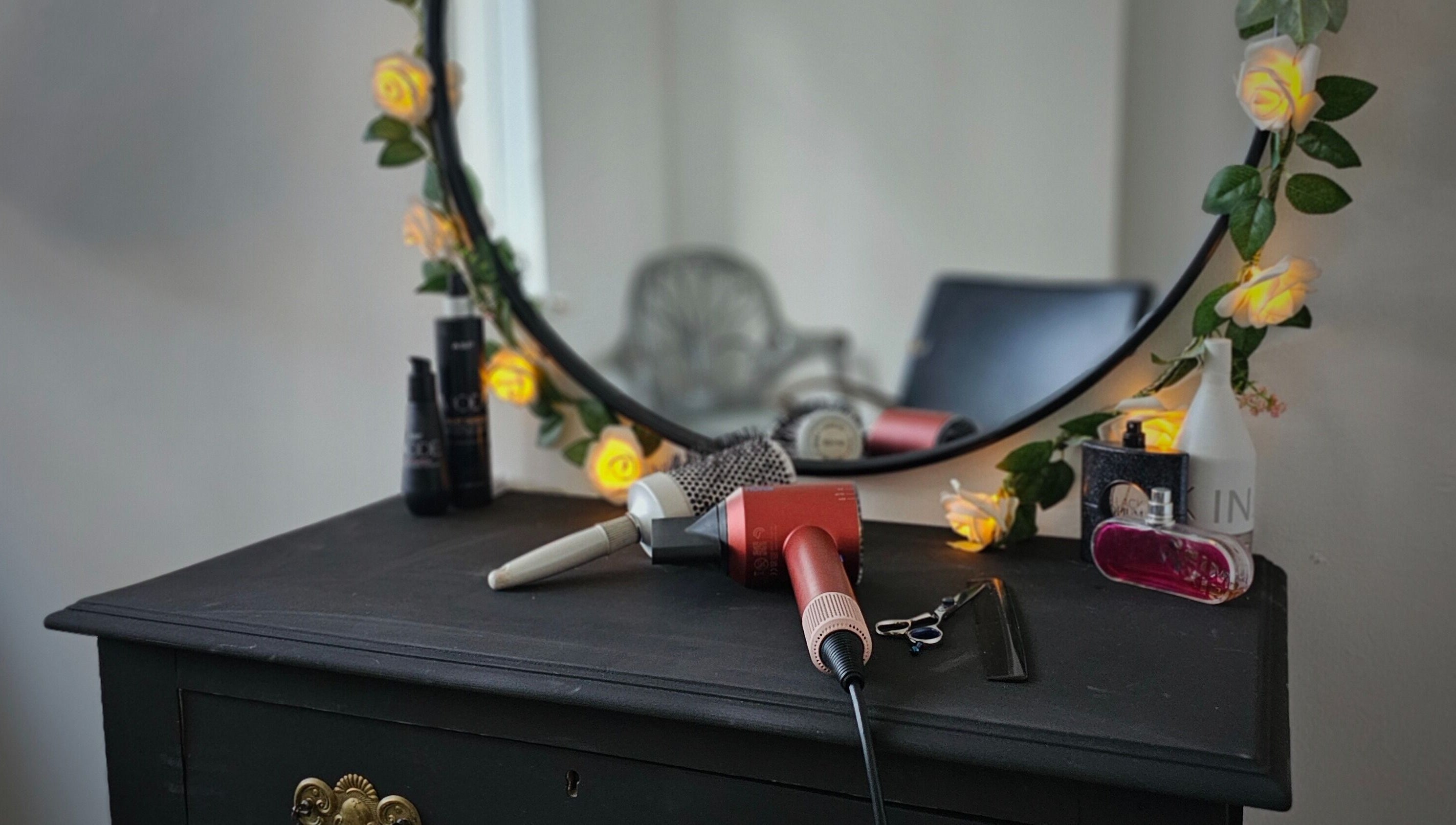 Elegant vanity setup at Taylor'd Hair, Catterick Garrison, England, GB with styling tools and floral decor.