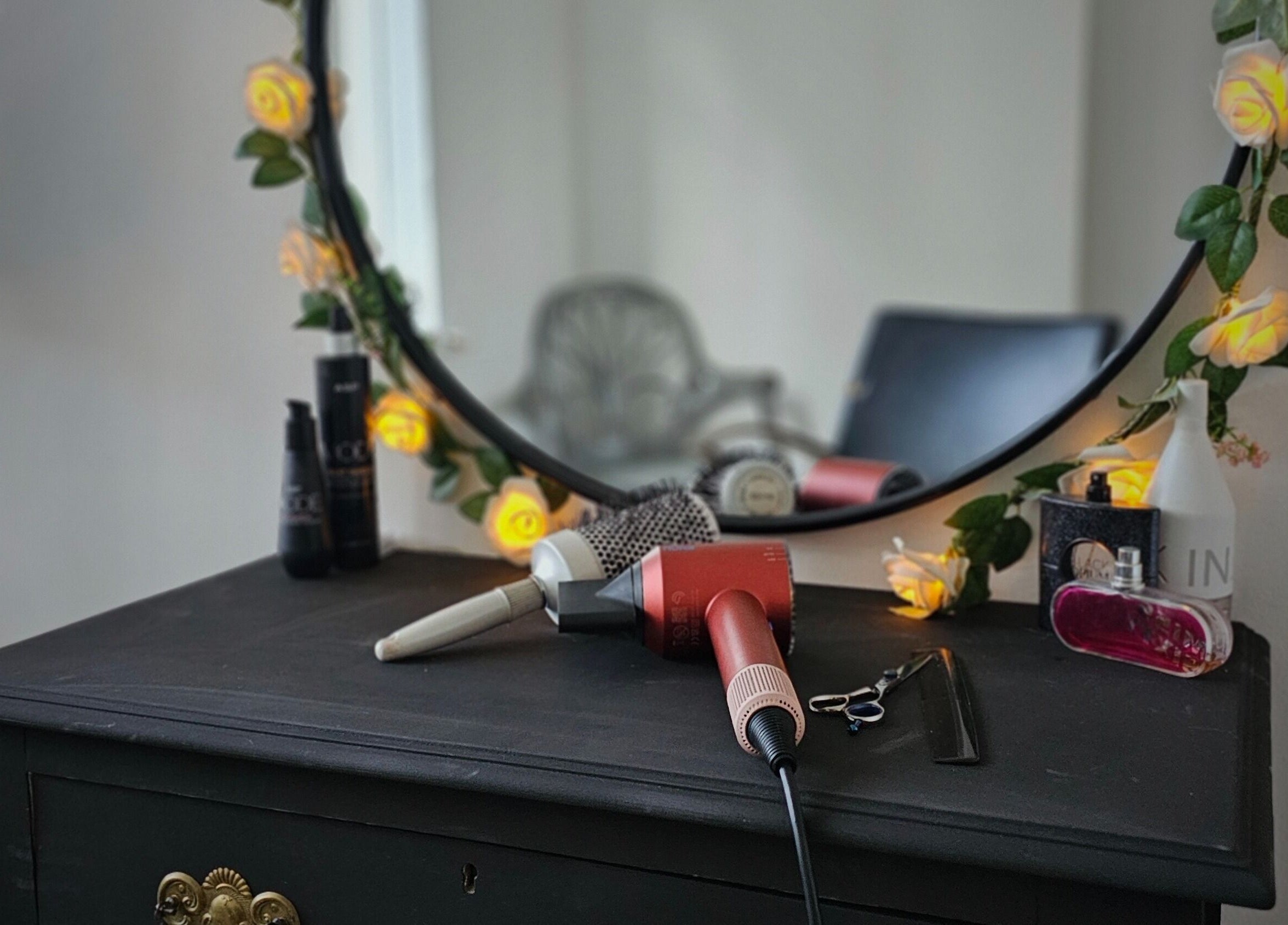 Elegant vanity setup at Taylor'd Hair, Catterick Garrison, England, GB with styling tools and floral decor.