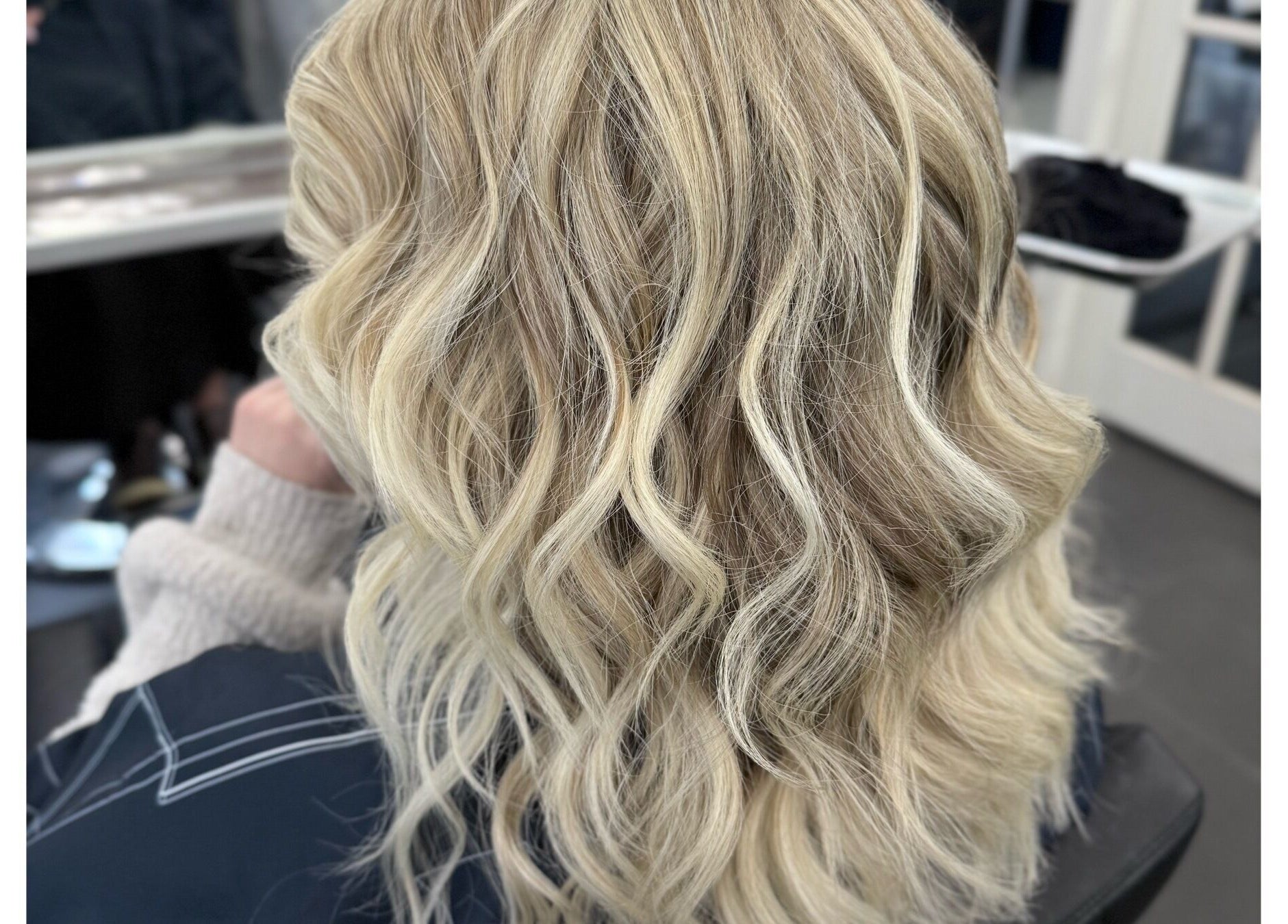 Blonde wavy hairstyle at Sheena McCart, Vancouver, British Columbia, CA, showcasing luxury hair treatment.