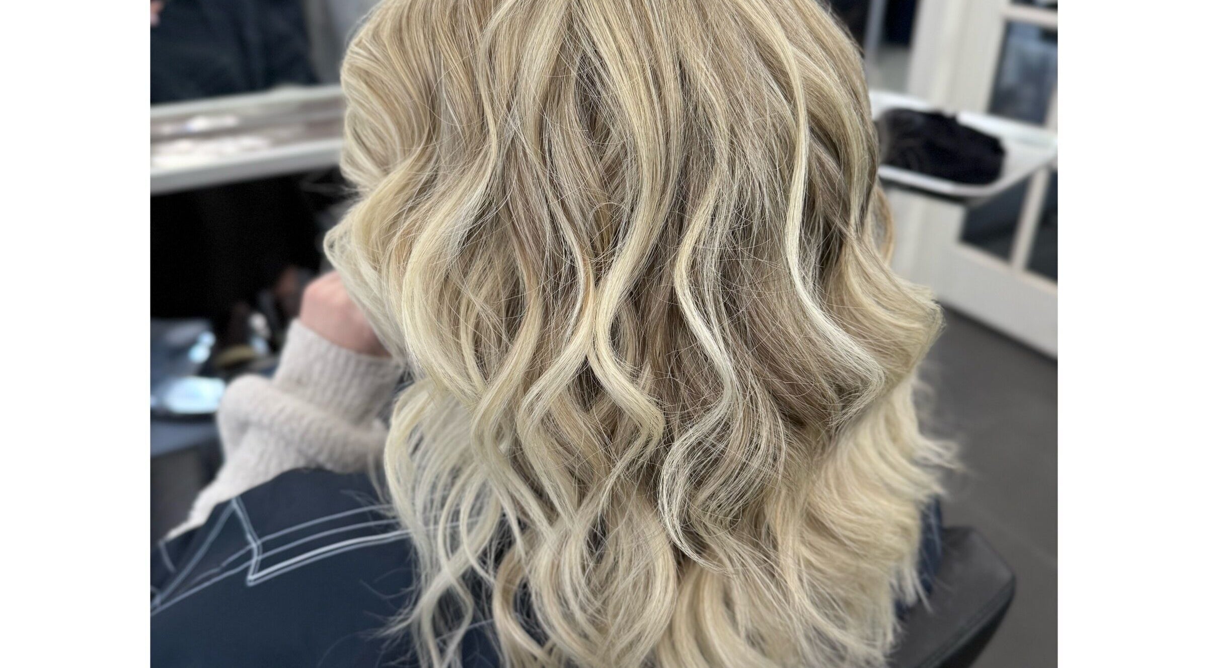 Blonde wavy hairstyle at Sheena McCart, Vancouver, British Columbia, CA, showcasing luxury hair treatment.