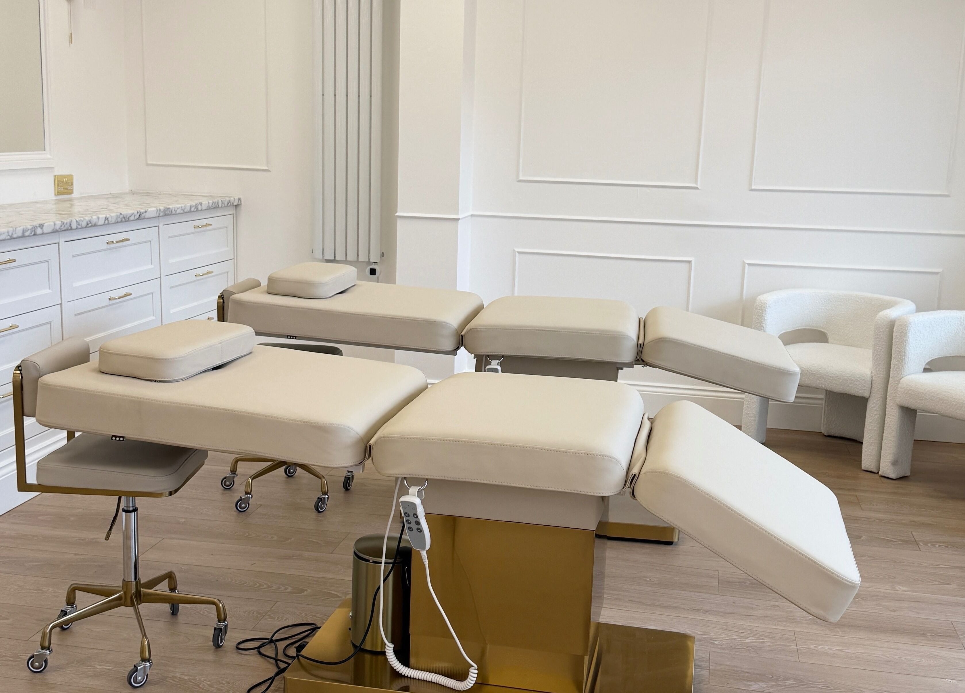 Luxurious treatment room at Studio 22 in Ripley, England, GB with modern beige chairs and sleek counters.