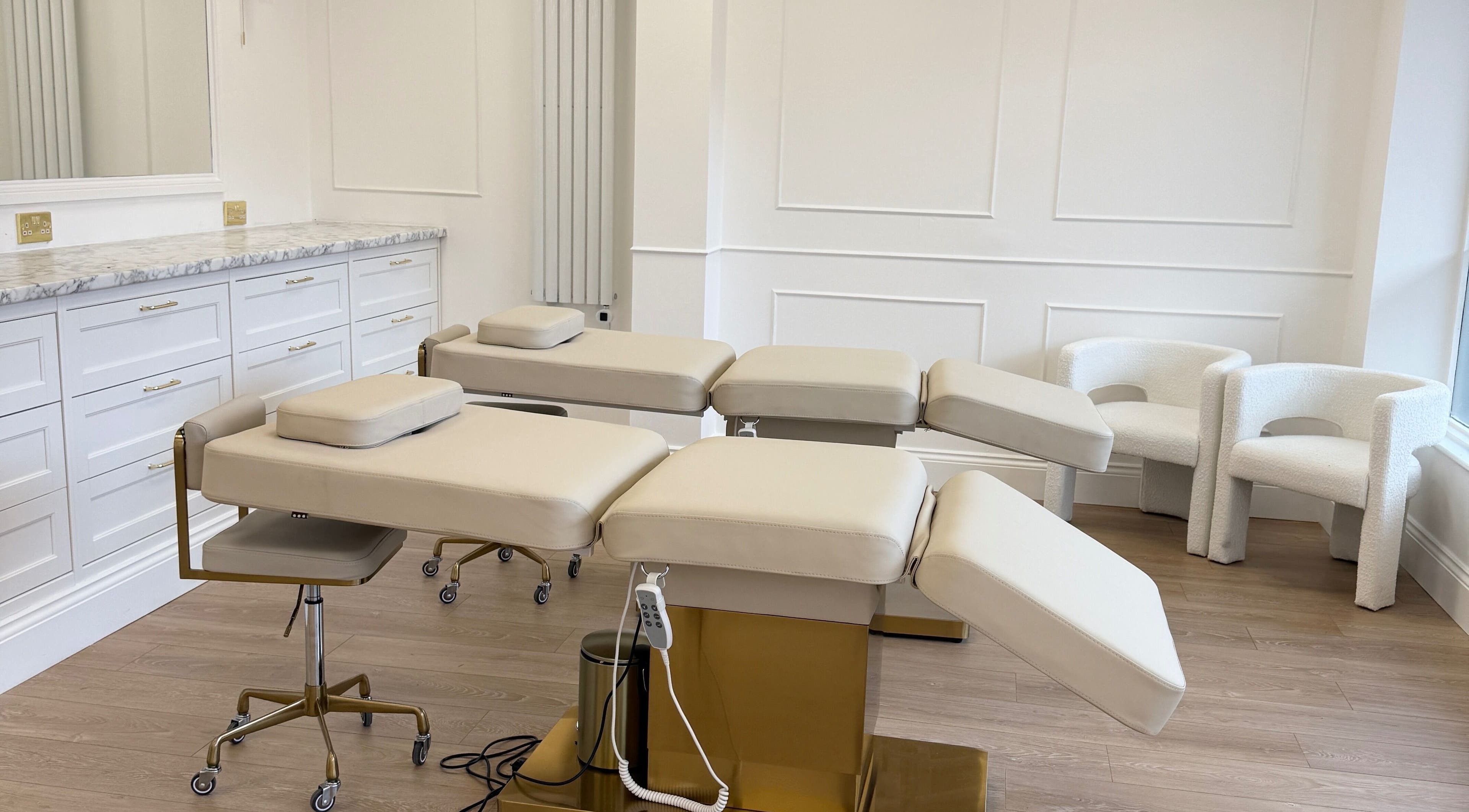 Luxurious treatment room at Studio 22 in Ripley, England, GB with modern beige chairs and sleek counters.