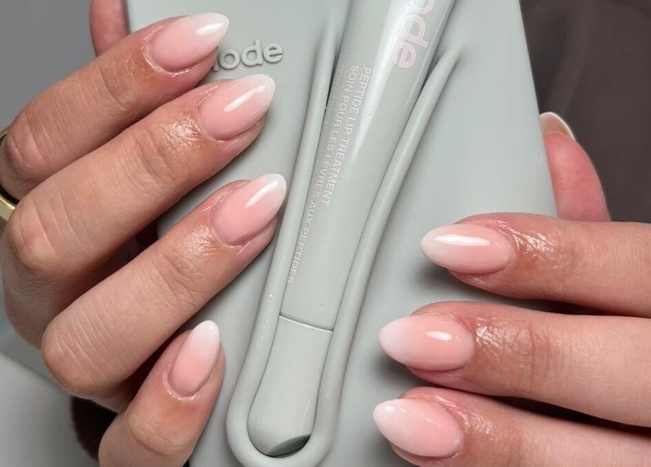 Close-up of manicured hands holding a product at Studio 22, Ripley, England, GB. Perfectly polished pink nails.