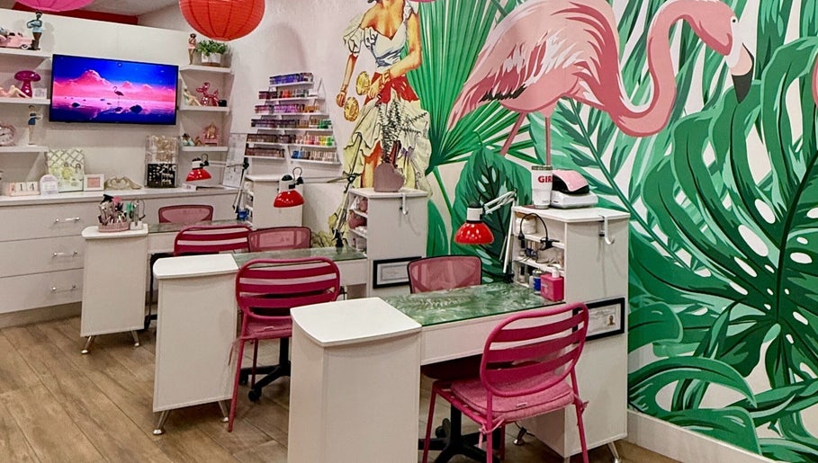 Vibrant nail salon at That Girl Beauty Bar, Miami, Florida, US, with tropical decor and pink chairs.