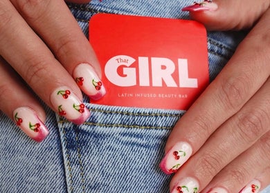 Manicured nails with cherry design holding That Girl Beauty Bar card, Miami, Florida, US.