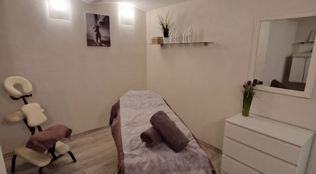Calm massage room at Ķermeņa procedūras Pārdaugavā in Rīga, LV, featuring massage table and tranquil decor.