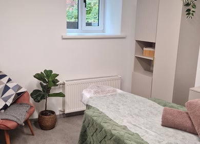 Serene treatment room at Ķermeņa procedūras Pārdaugavā, Rīga, LV with a plush chair and massage table.