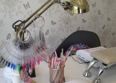 Mesa de manicure do Studio Inês C Nails em Baixa Da Banheira, Setúbal, PT, com ferramentas e amostras de unhas.