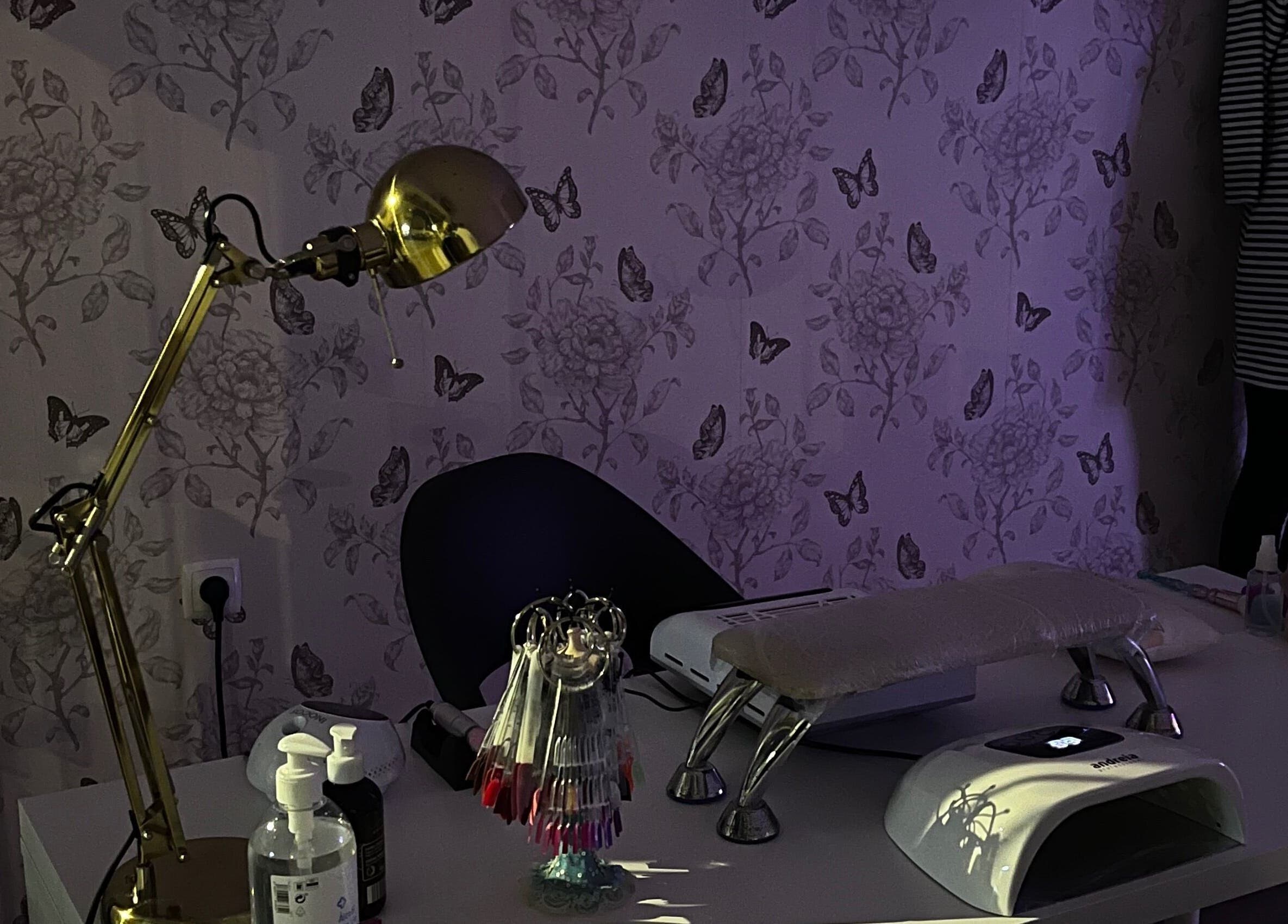 Mesa de manicure elegante no Studio Inês C. Nails, Baixa Da Banheira, PT, com decoração floral e iluminação suave.