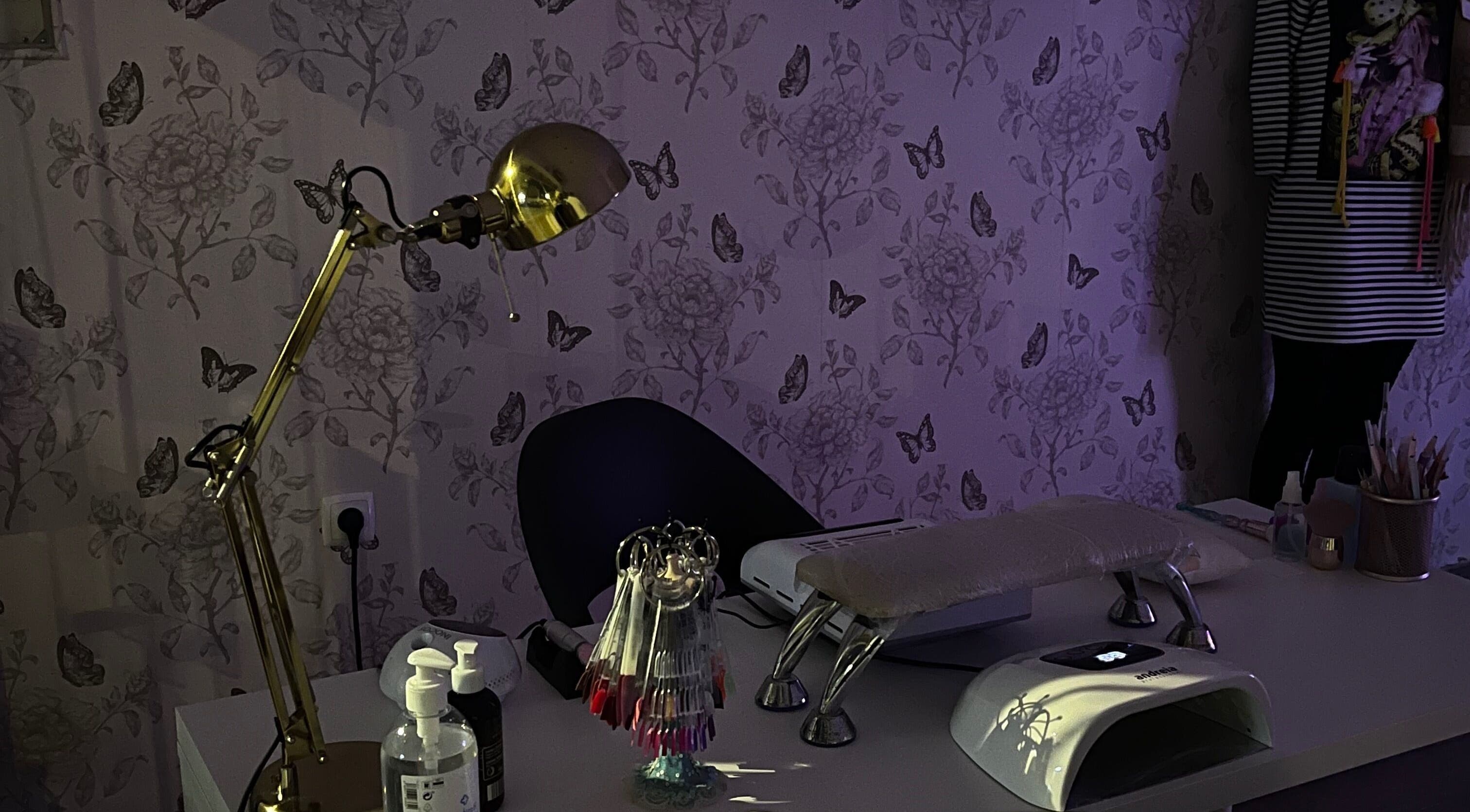 Mesa de manicure elegante no Studio Inês C. Nails, Baixa Da Banheira, PT, com decoração floral e iluminação suave.