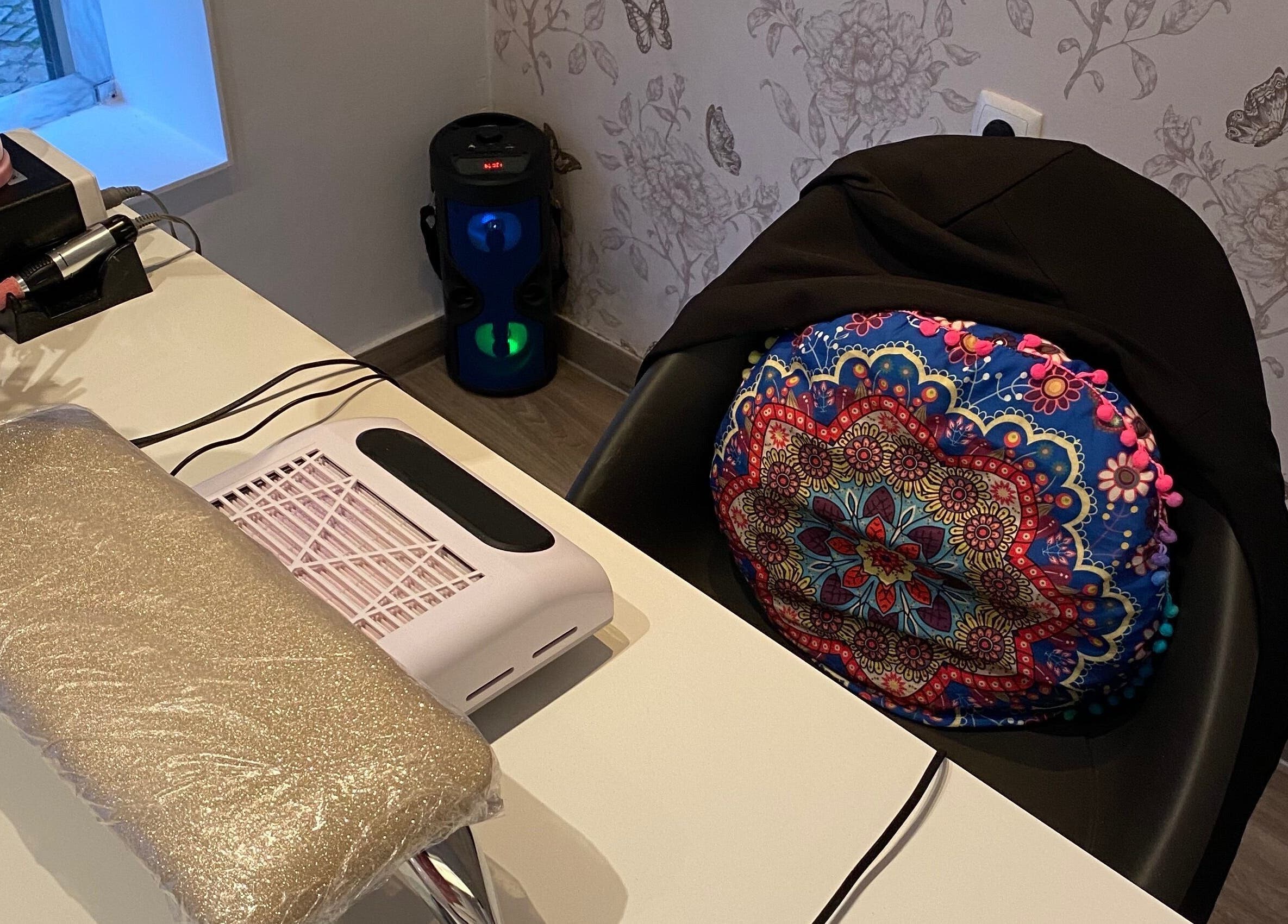 Espaço de manicure decorado no Studio Inês C. Nails, Baixa Da Banheira, PT, com almofada colorida vibrante.