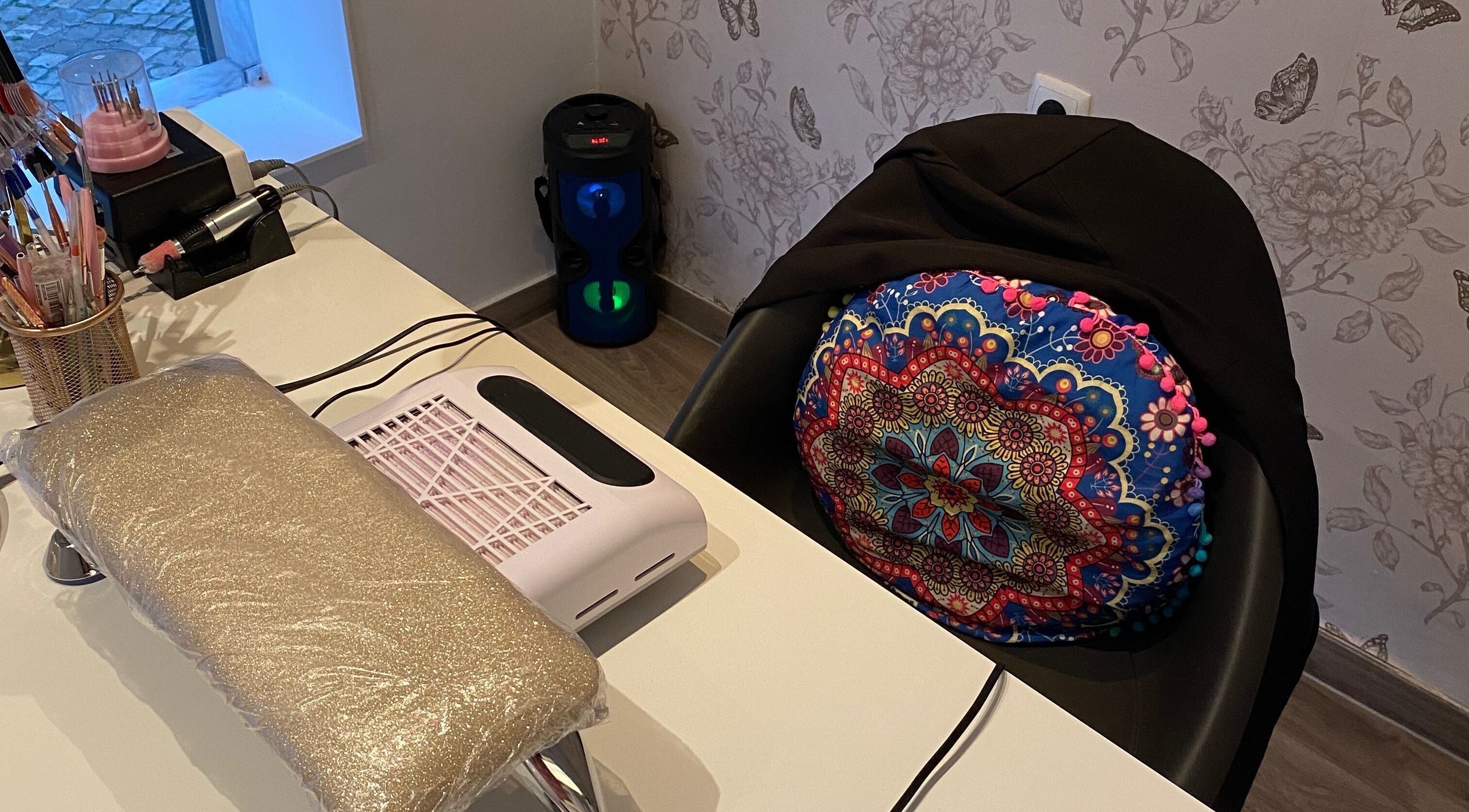 Espaço de manicure decorado no Studio Inês C. Nails, Baixa Da Banheira, PT, com almofada colorida vibrante.