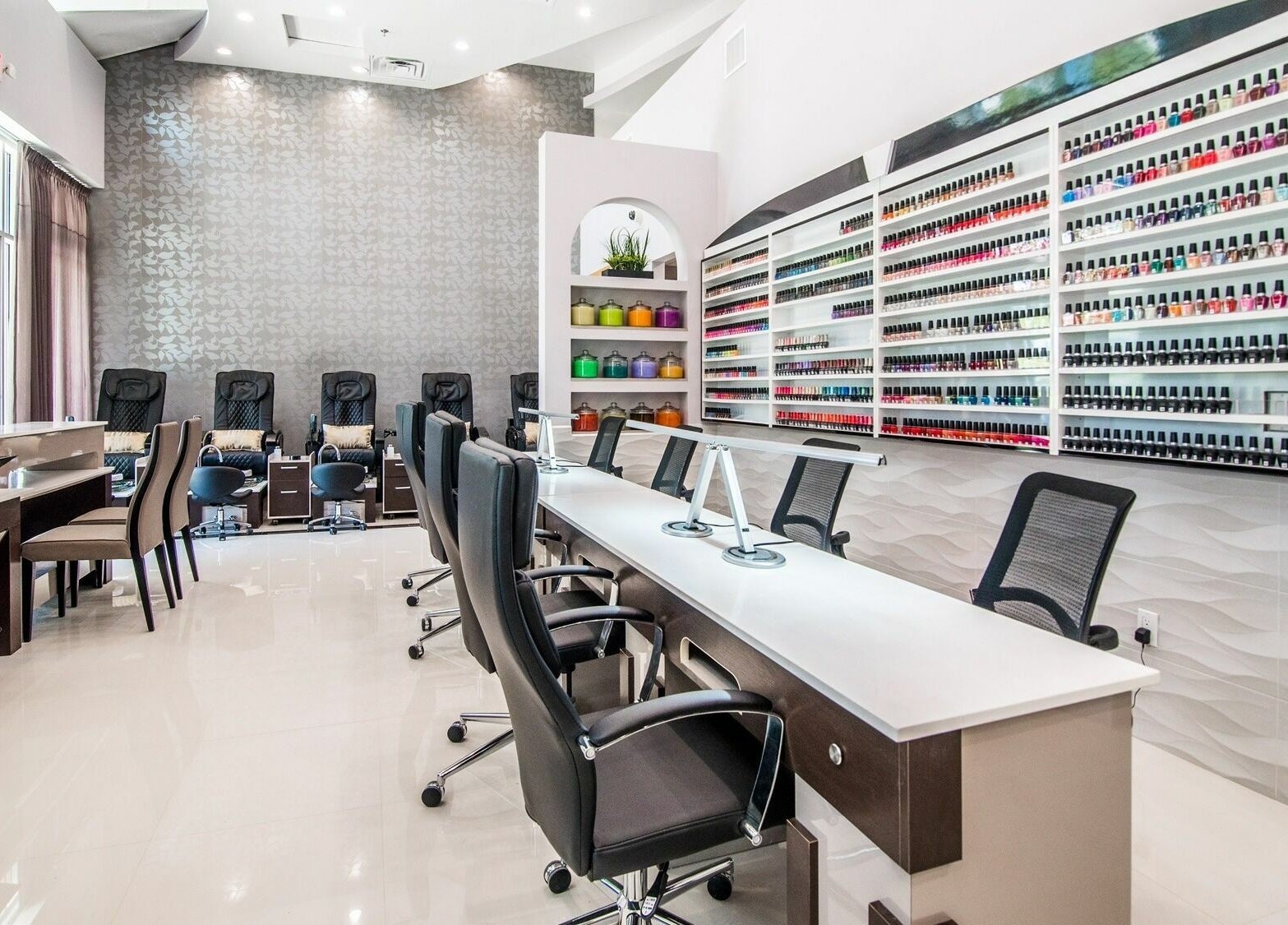 Elegant interior of Glow Spa and Nails in Houston, Texas, US; showcases modern chairs and vast nail polish selection.