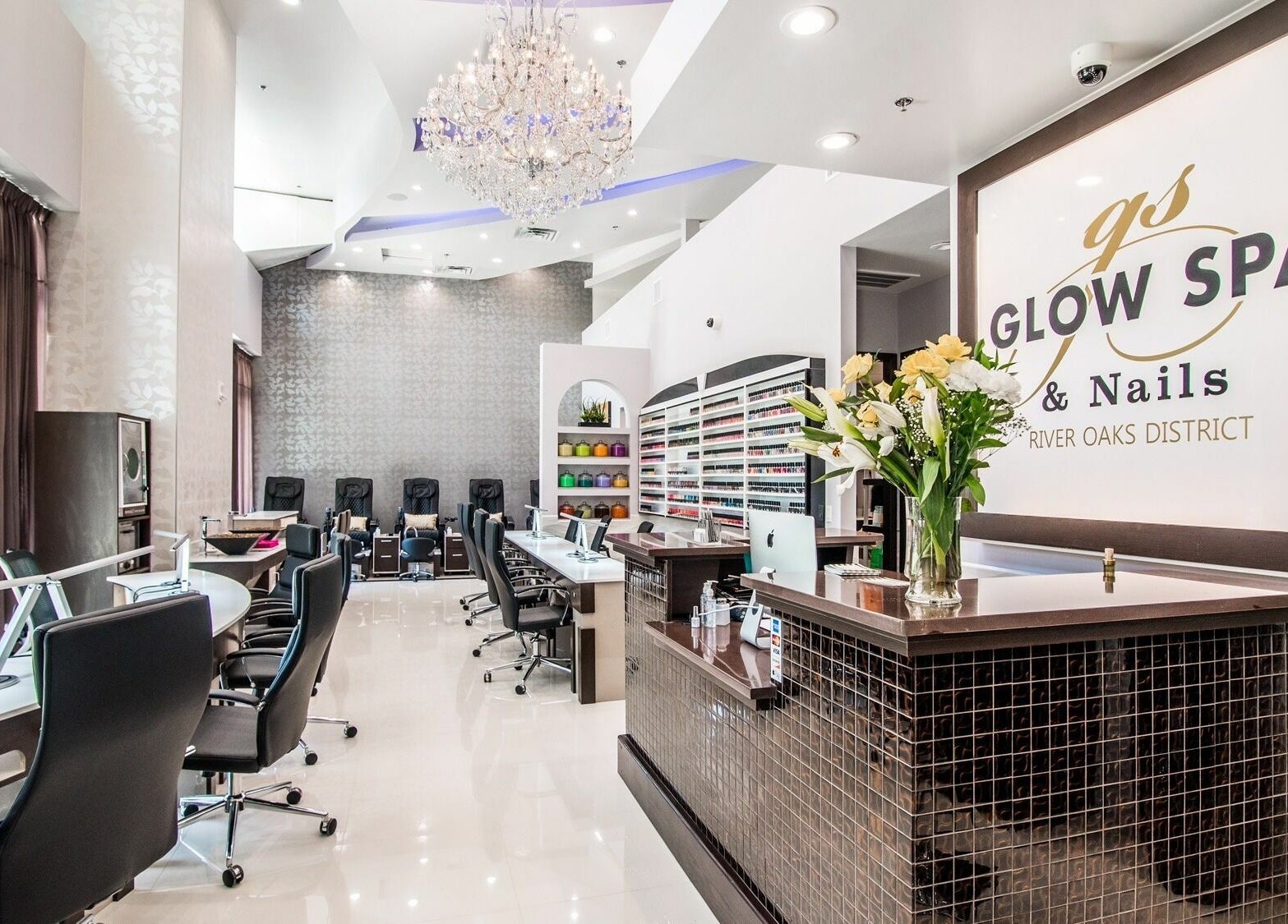 Elegant interior of Glow Spa and Nails in Houston, Texas, US, showcasing manicure tables and nail polish wall.