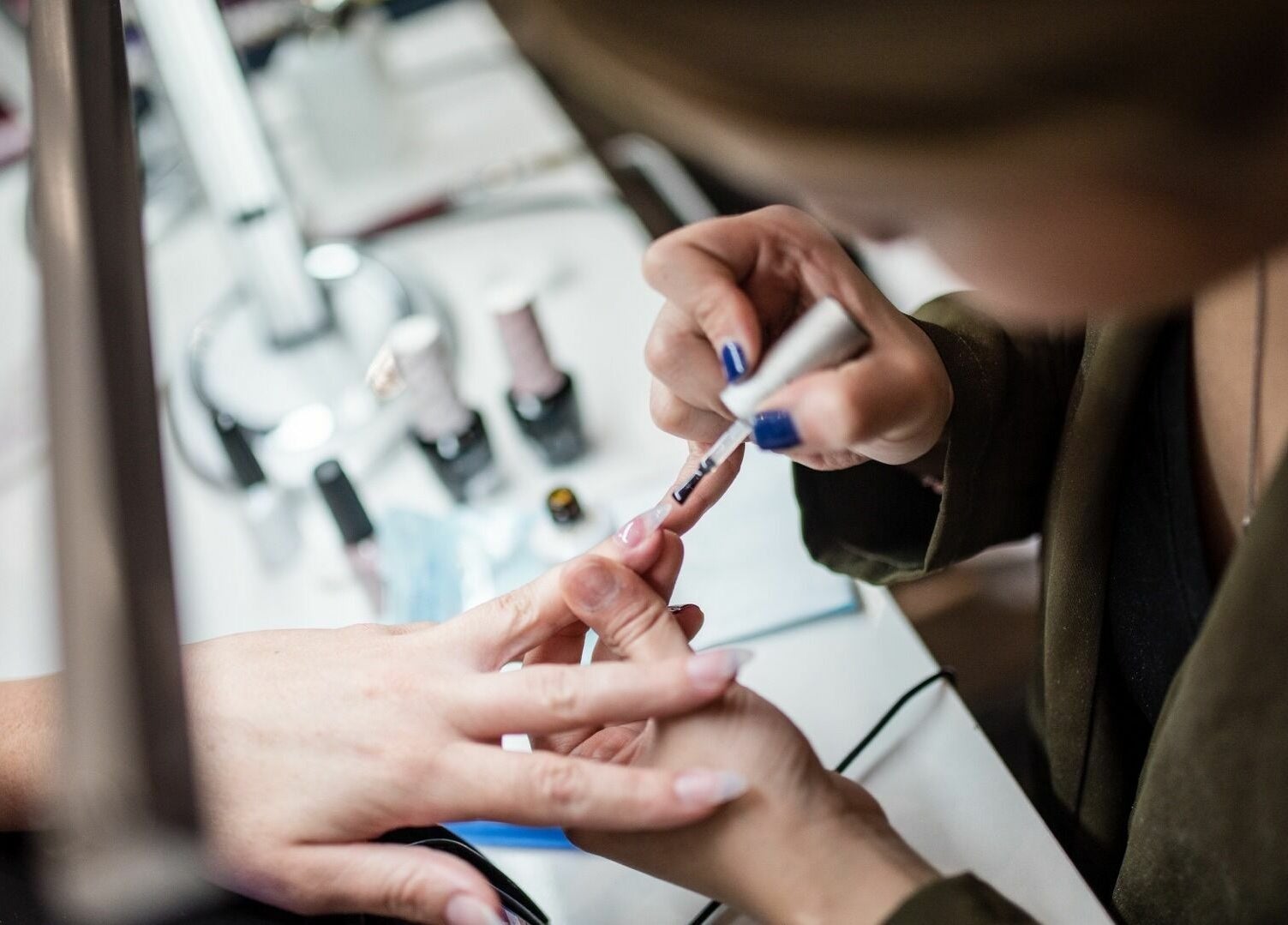 Nail artist applying polish at Glow Spa and Nails, Houston, Texas, US.