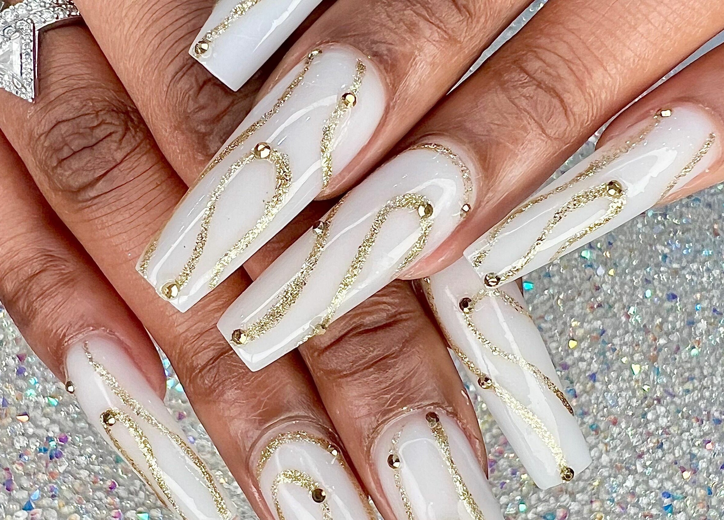 Elegant nail art with gold accents at Glow Spa and Nails, Houston, Texas, US, showcasing intricate design details.