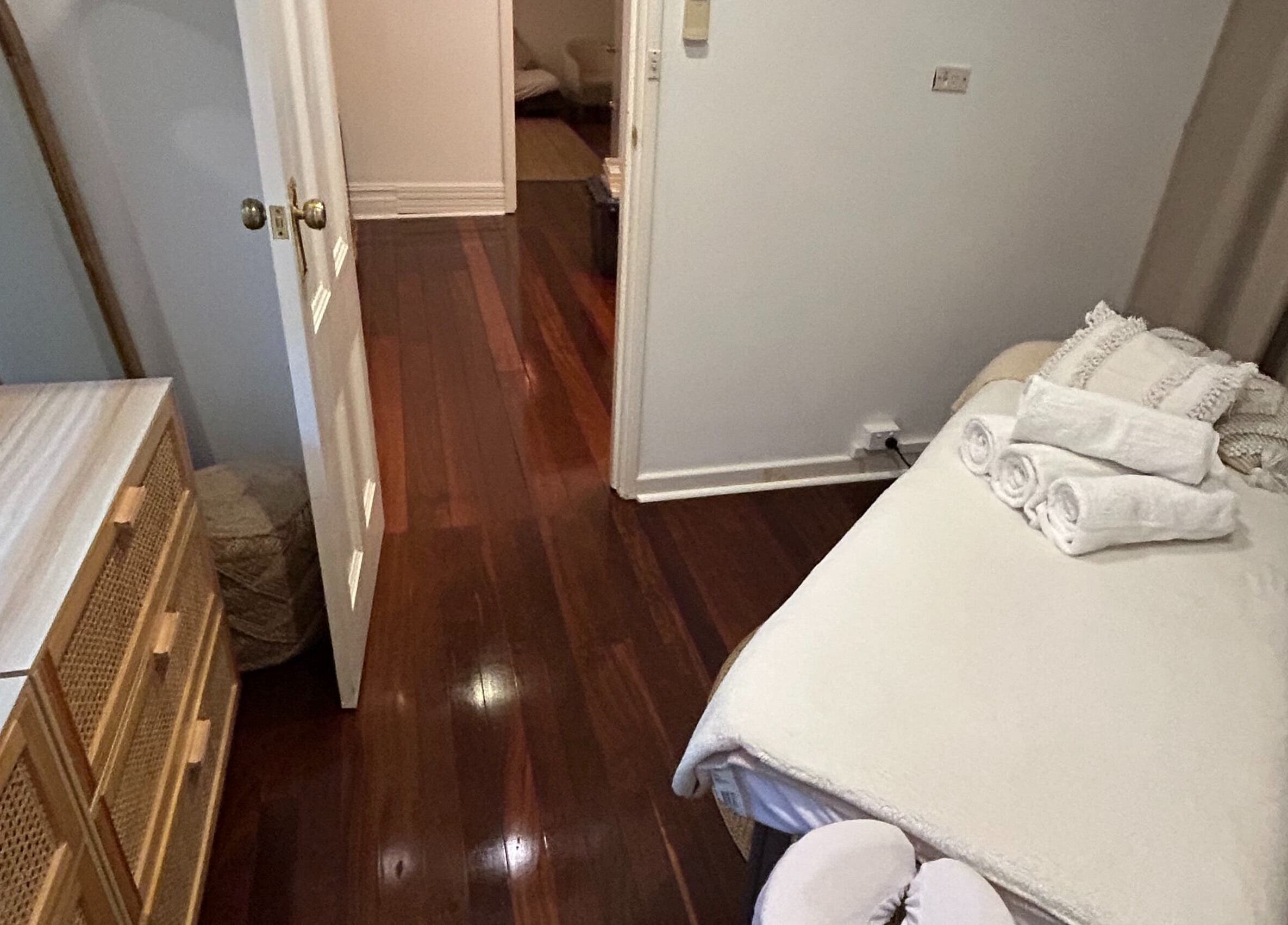 Relaxing massage room at Palm Beach Wellness Nedlands, featuring soft linens and wooden decor in Nedlands, Western Australia, AU.