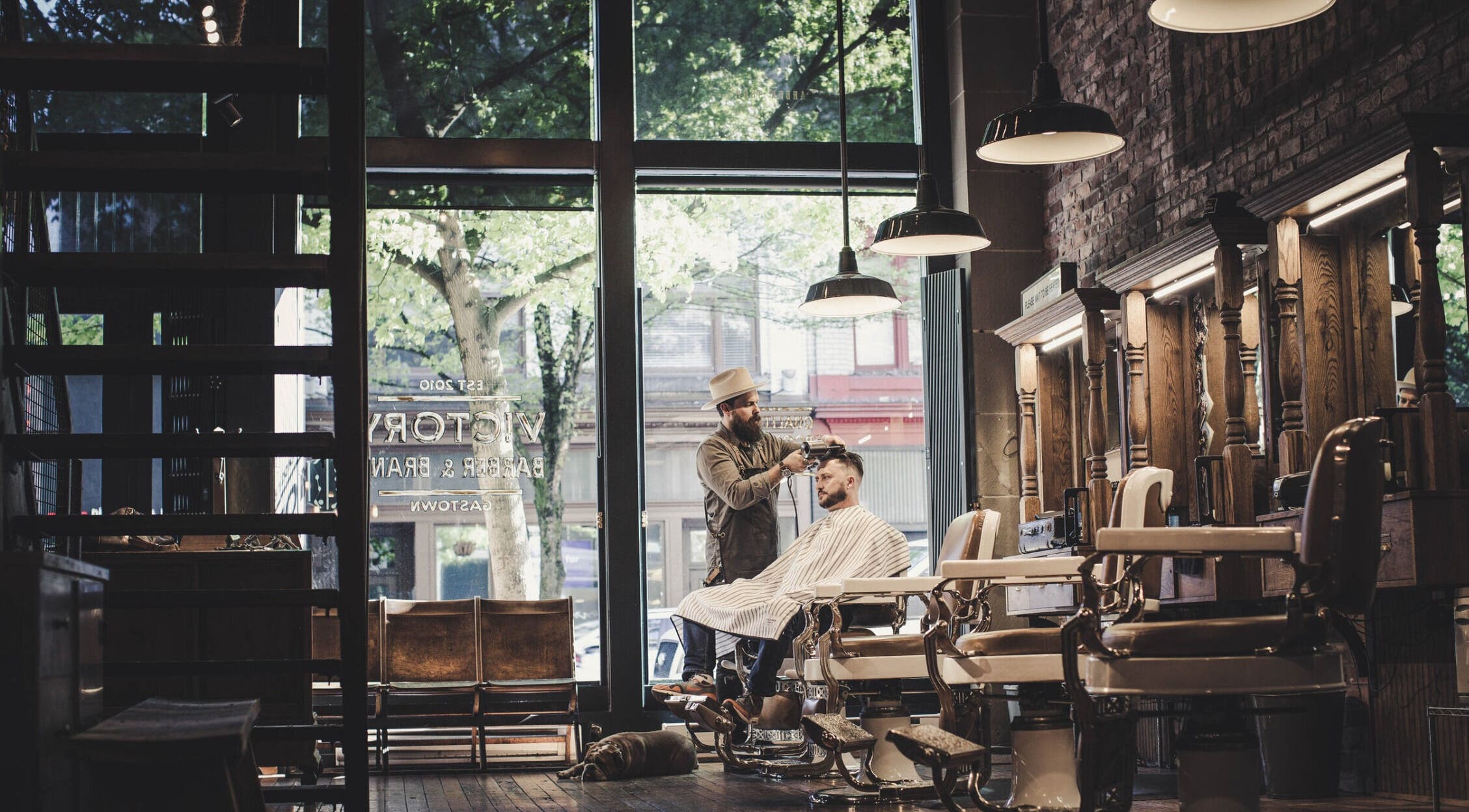 Interior view of Bandz Tha Barber in Vancouver, British Columbia, CA, showcasing vintage barber chairs and wood decor.