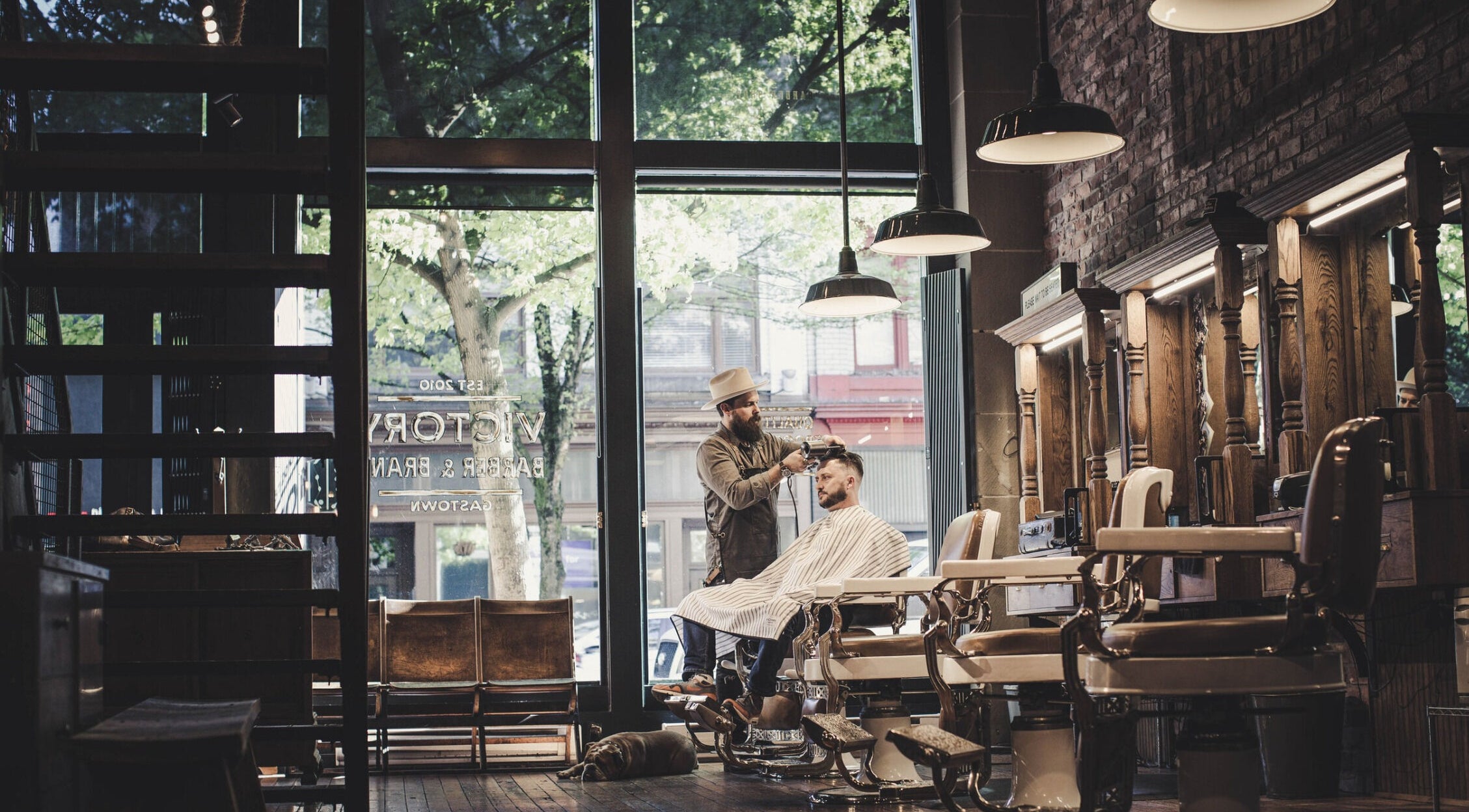 Interior view of Bandz Tha Barber in Vancouver, British Columbia, CA, showcasing vintage barber chairs and wood decor.