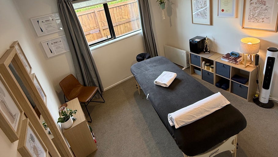 Relaxing therapy room at Recover Well Massage Therapy, Rolleston, Canterbury, NZ with massage table and decor.