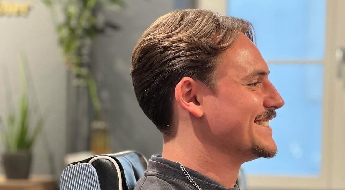 Client souriant chez Anaïs Cerqueira Chez SB Coiffure à Genève, Genève, CH, montrant une coiffure moderne.