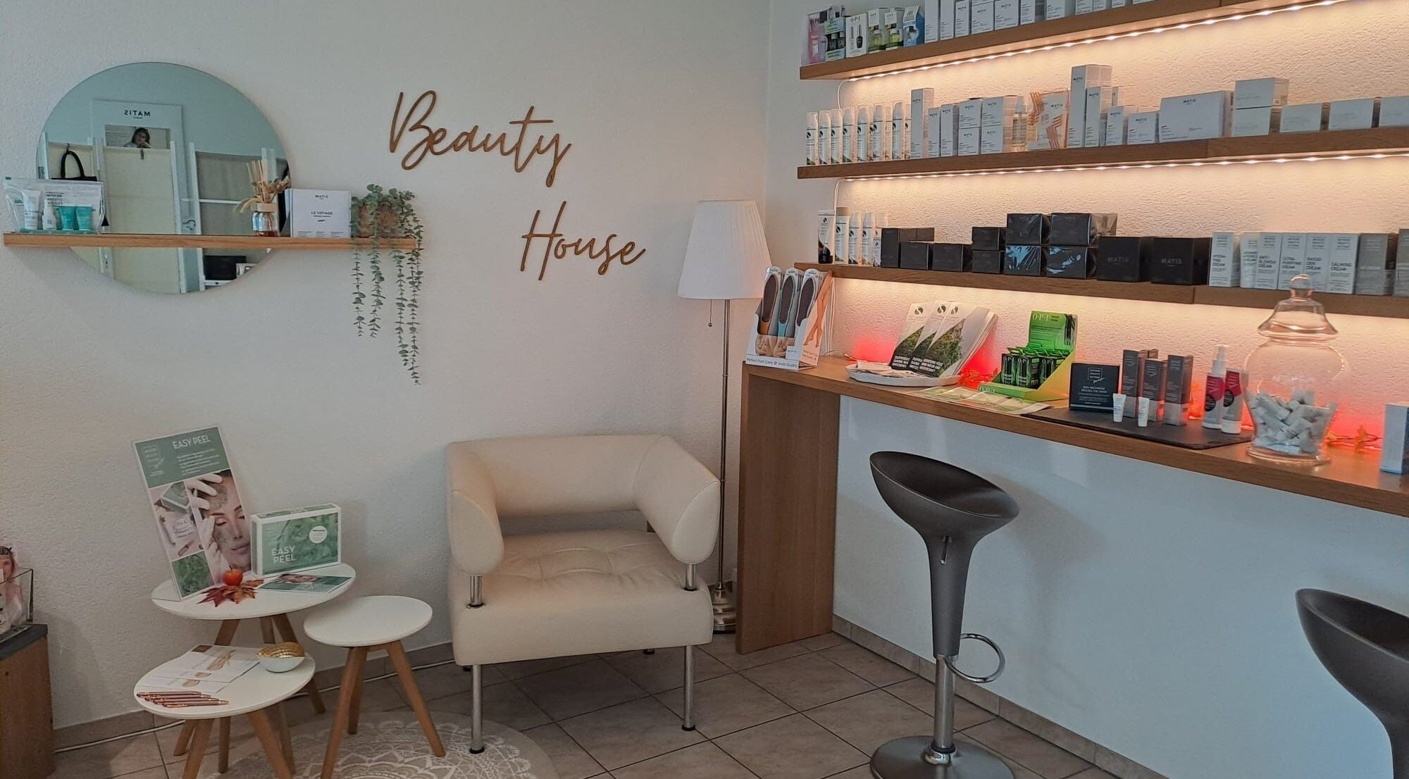 Moderne Lounge im Beauty House Brugg, Brugg, Aargau, CH mit stilvollen Möbeln und Pflegeprodukten.