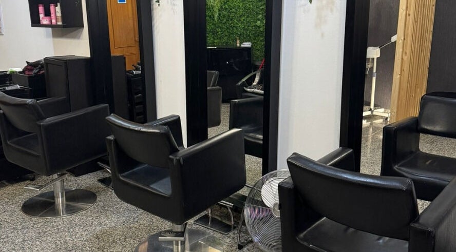 Interior do T.A cabeleireiros & Estética - Arrois em Lisboa, Lisboa, PT, com cadeiras elegantes e espelhos.