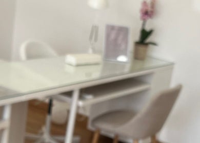 Sala de tratamento minimalista no Ana Gomes Estética, Perelhal, Braga, PT, com mesa branca e orquídea.