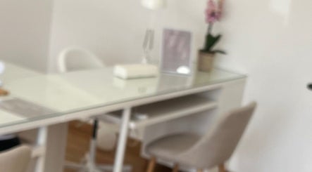 Sala de tratamento minimalista no Ana Gomes Estética, Perelhal, Braga, PT, com mesa branca e orquídea.