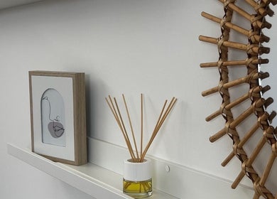 Decoração elegante na Ana Gomes Estética em Perelhal, Braga, PT, com difusor e espelho de vime.