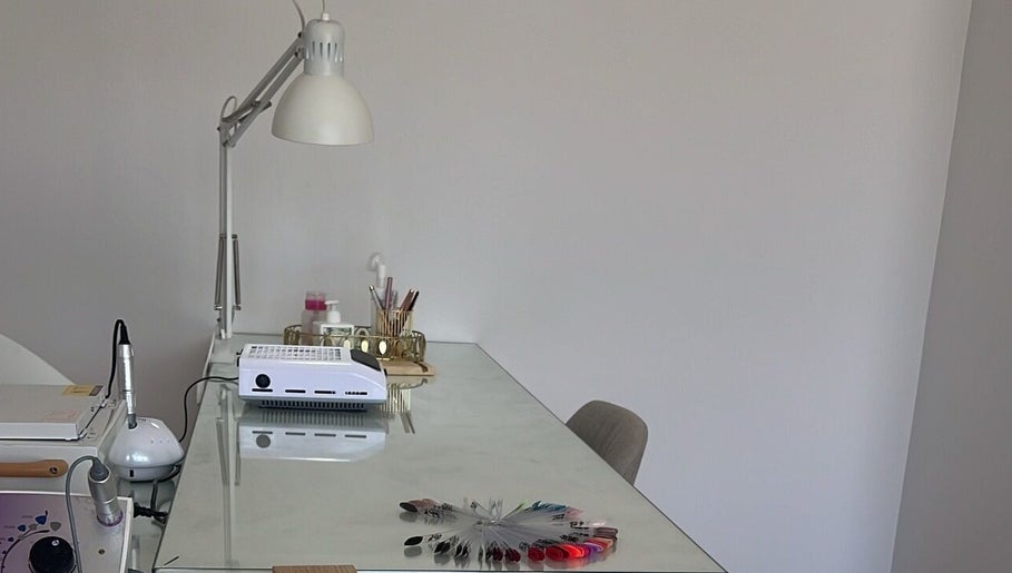 Mesa de manicure em Ana Gomes Estética, Perelhal, Braga, PT, com lâmpada e ferramentas de beleza.