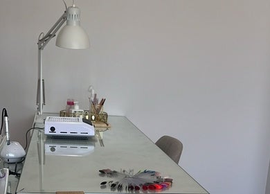 Mesa de manicure em Ana Gomes Estética, Perelhal, Braga, PT, com lâmpada e ferramentas de beleza.