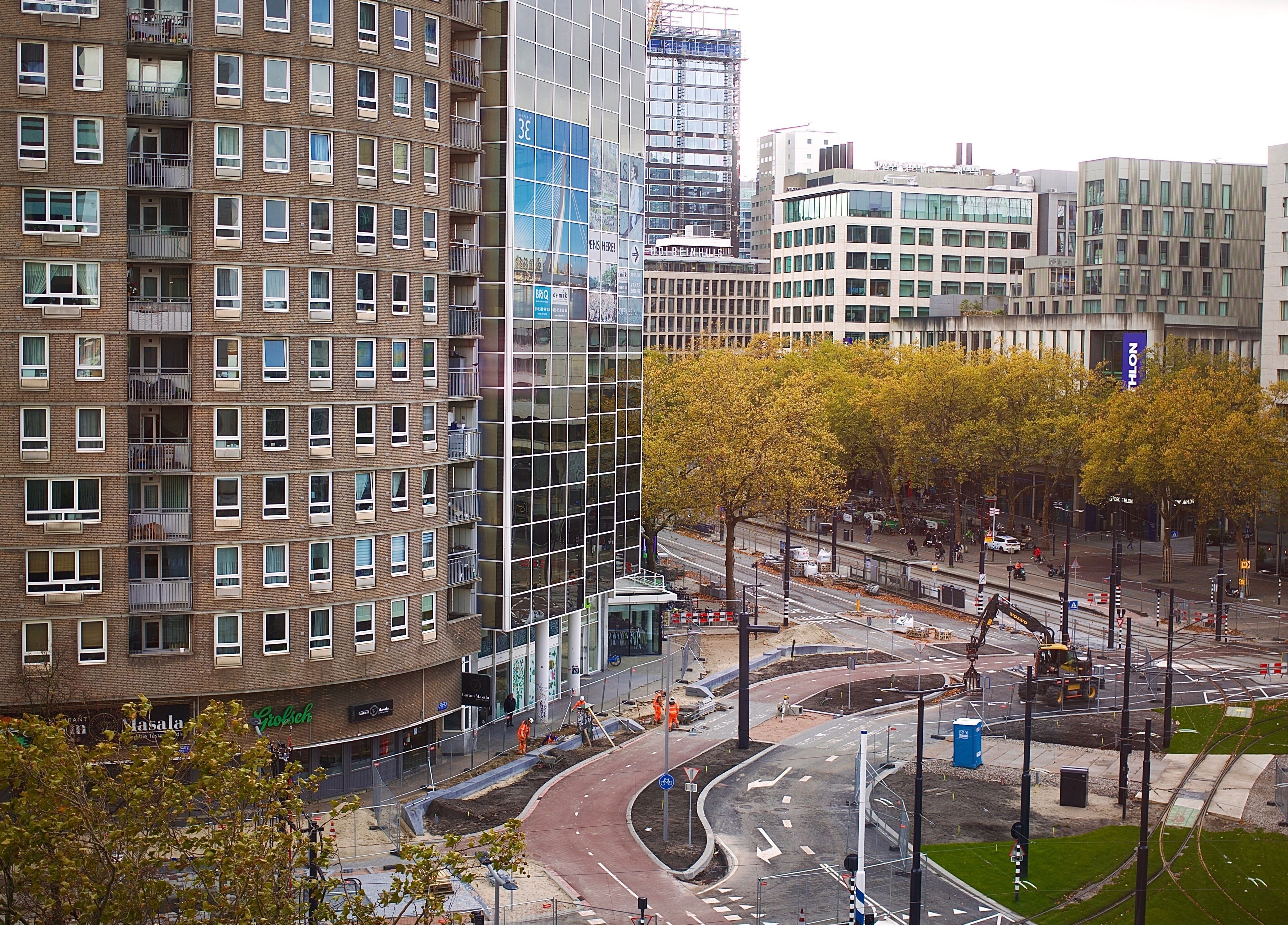 Straatzicht nabij Ferra Cuts in Rotterdam, Zuid-Holland, NL, met moderne gebouwen en groene bomen.