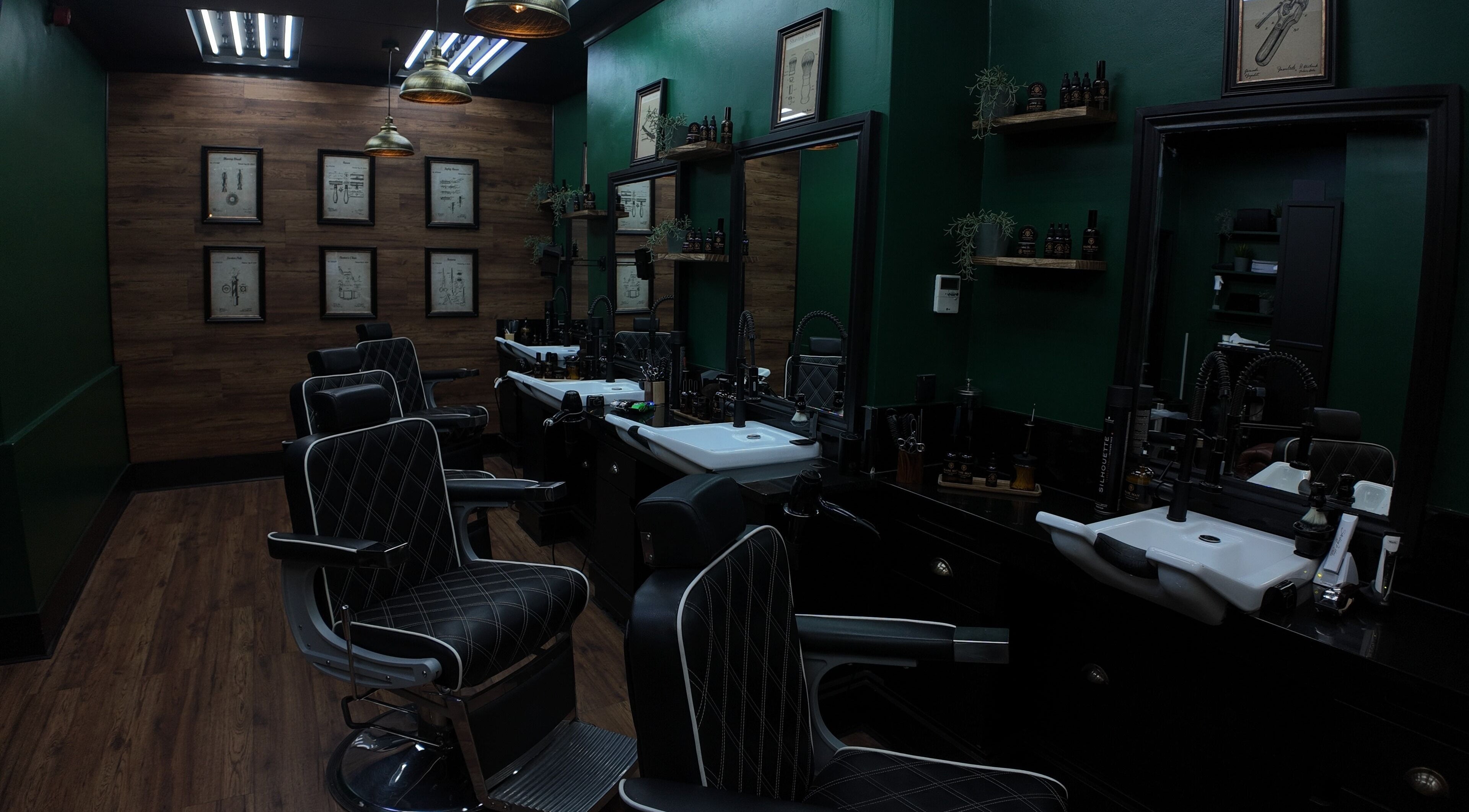 Elegant interior of Mane Man Grooming Ltd in London, England, GB with sleek barber chairs and wooden decor.