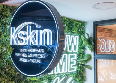 Kskin Korean Express Facial signage at Chinatown Point, Singapore, SG, surrounded by lush greenery decor.