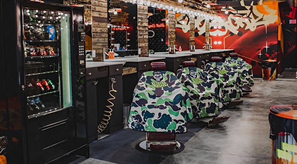 Interior moderno de Gorilla Barber en Miami, Florida, US con sillas estilizadas y decoración urbana.