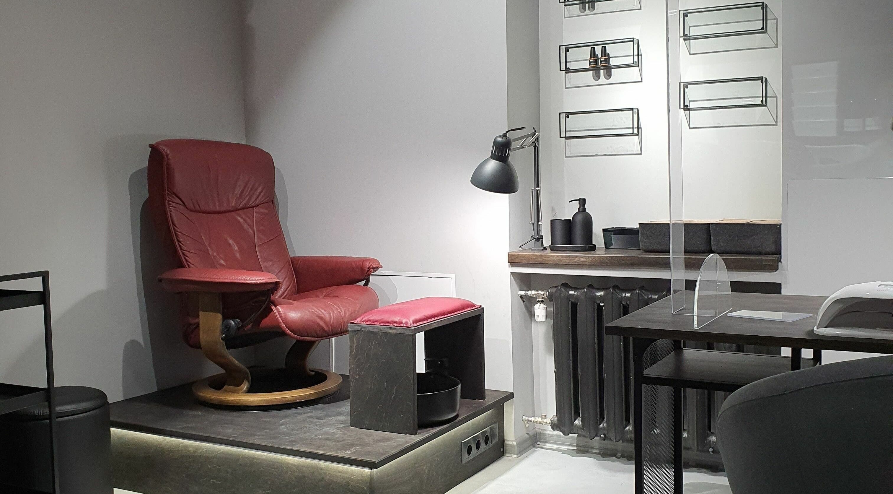 Relaxing setup with red chair at Hairport Studija, Rīga, LV. Ideal for personalized beauty treatments.