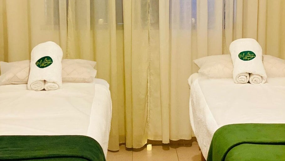Sala de massagem tranquila no Massage Village em Pinhal Novo, Setúbal, PT, com duas camas preparadas.