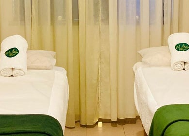 Sala de massagem tranquila no Massage Village em Pinhal Novo, Setúbal, PT, com duas camas preparadas.