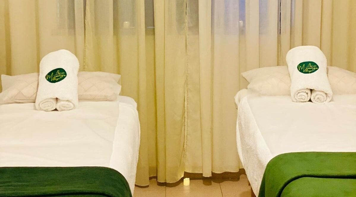 Sala de massagem tranquila no Massage Village em Pinhal Novo, Setúbal, PT, com duas camas preparadas.