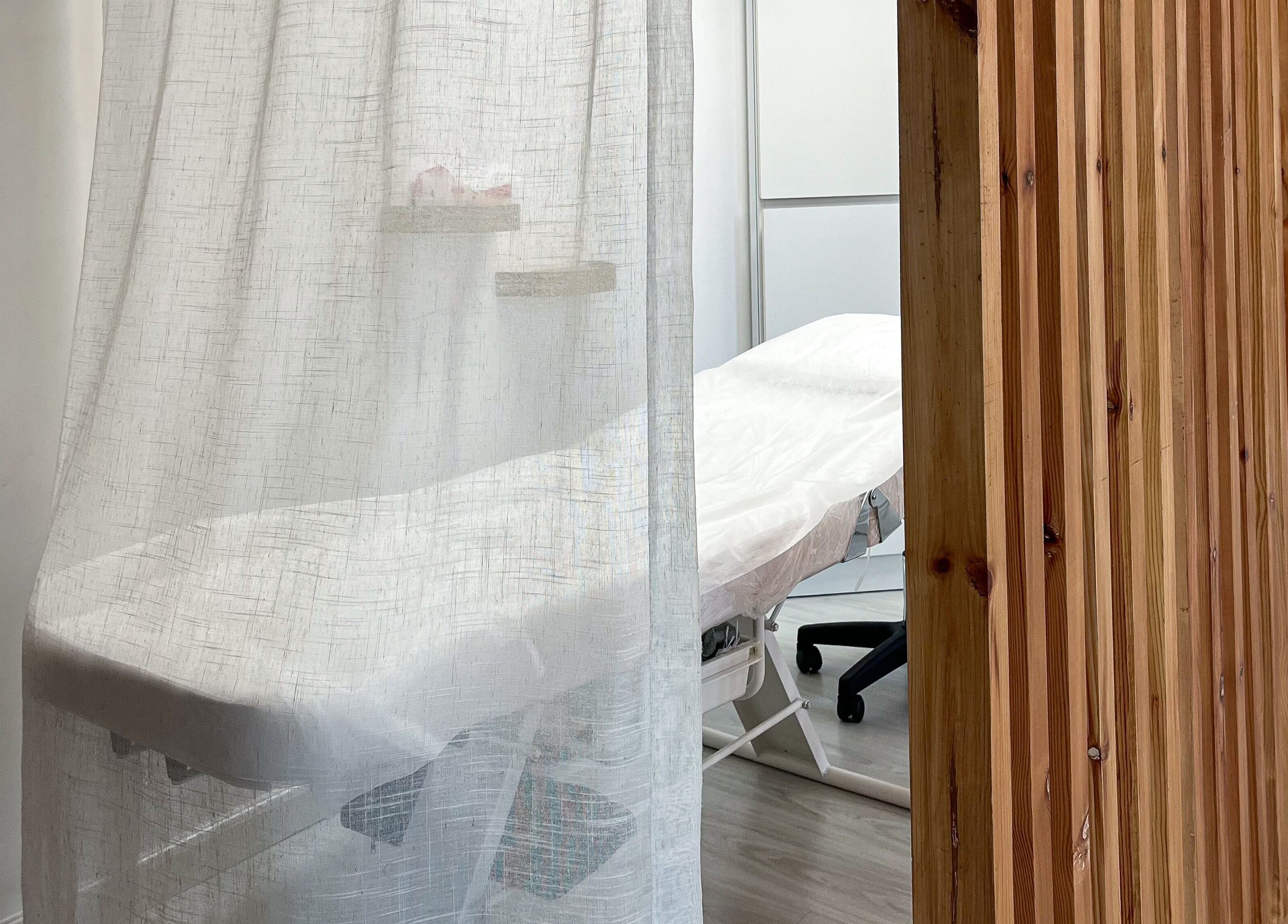 Relaxing treatment room at Mona Beauty in Jeddah, Makkah Province, SA, with soft curtains and a comfy massage table.